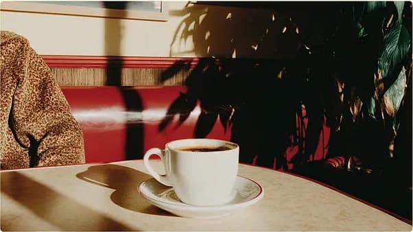A finished cup of coffee in a sunlit café